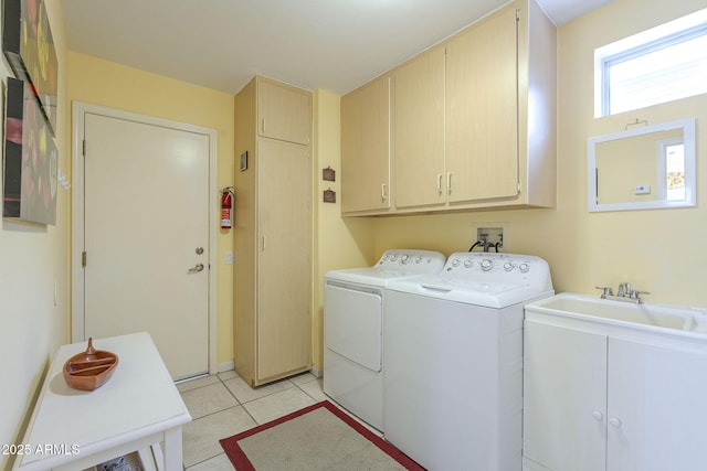 laundry area with light tile patterned floors, cabinet space, independent washer and dryer, and a sink