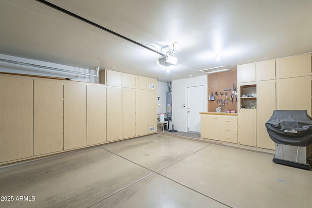 garage featuring water heater and a garage door opener