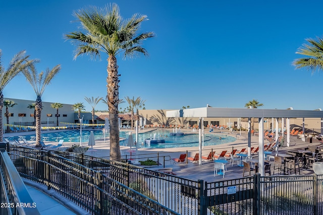 pool with a patio and fence