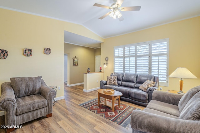 living room featuring wood finished floors, baseboards, lofted ceiling, ornamental molding, and ceiling fan