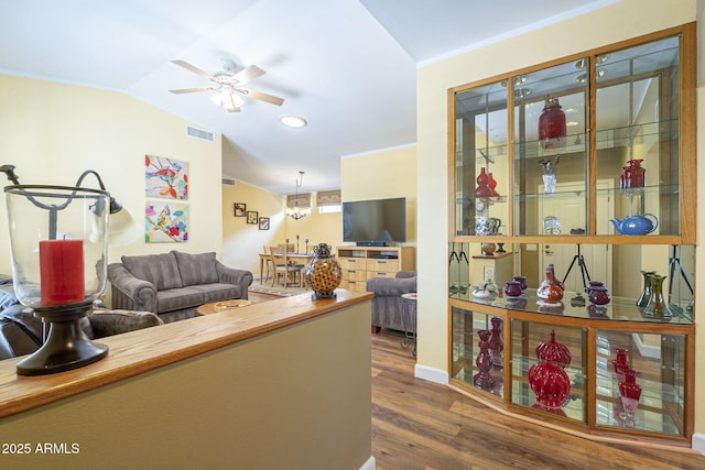 living area with wood finished floors, visible vents, lofted ceiling, and ceiling fan