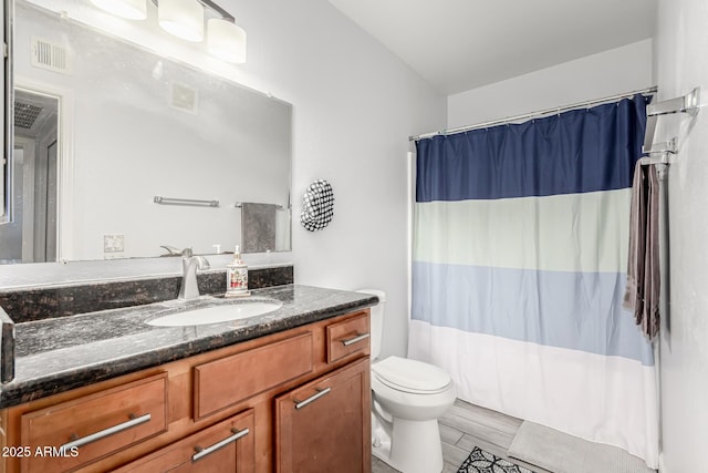 bathroom featuring a shower with shower curtain, vanity, and toilet