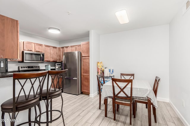 kitchen featuring light wood-type flooring and appliances with stainless steel finishes