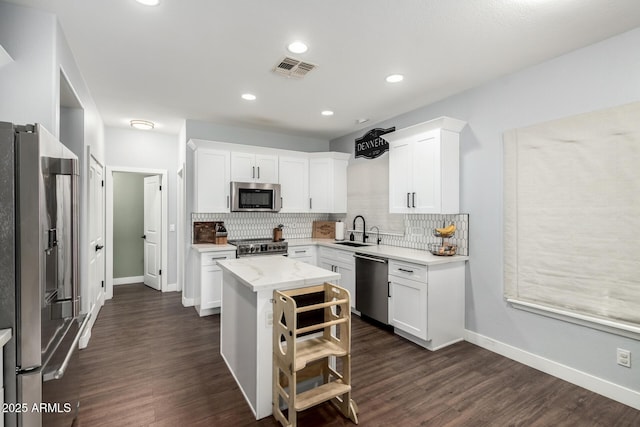 25210 N 40th Ave, Phoenix, AZ 85083 - kitchen with stainless steel appliances, tasteful backsplash, white cabinetry, dark wood-style floors, and recessed lighting