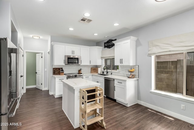 25210 N 40th Ave, Phoenix, AZ 85083 - kitchen with stainless steel appliances, backsplash, white cabinets, dark wood-style floors, and recessed lighting