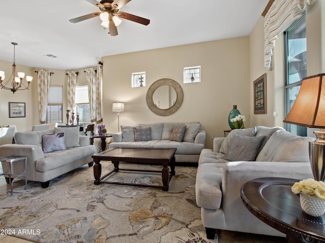 living room featuring ceiling fan with notable chandelier