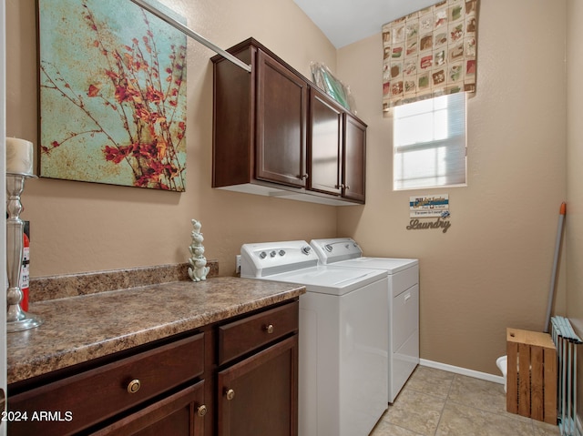 laundry room with radiator heating unit, cabinets, washer and dryer, and light tile patterned flooring