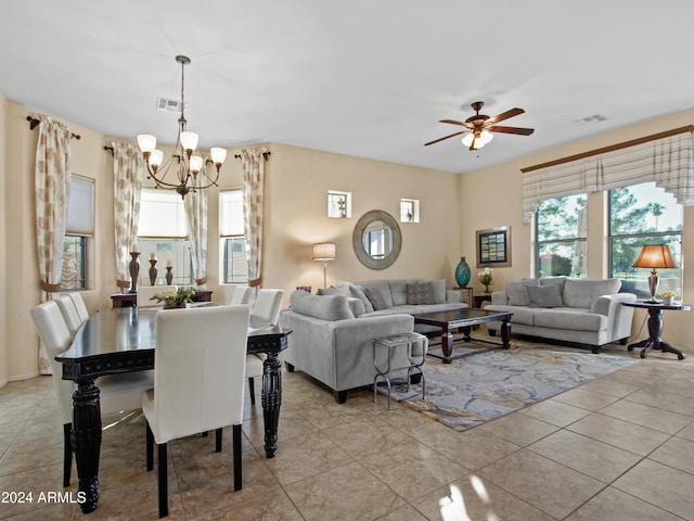 dining room with light tile patterned flooring and ceiling fan with notable chandelier