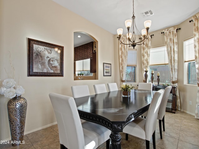 tiled dining room with a notable chandelier