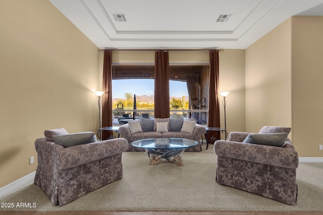 living room featuring carpet and a tray ceiling