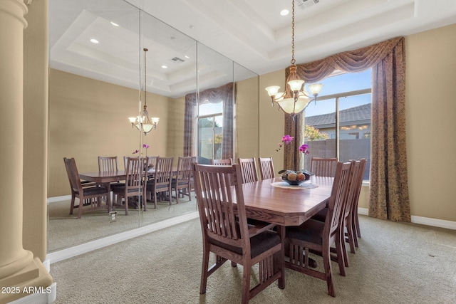 carpeted dining room with a raised ceiling, a notable chandelier, and ornate columns