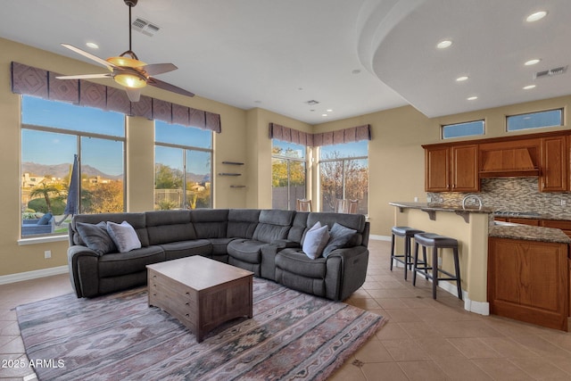 living room with a mountain view, light tile patterned floors, and ceiling fan