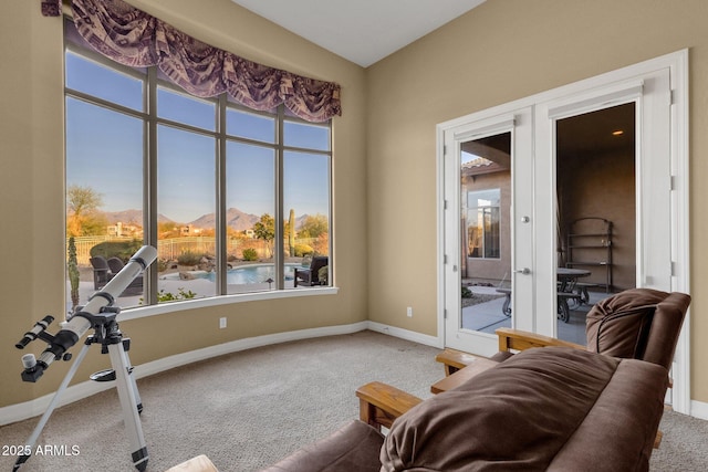 sitting room with carpet, a mountain view, and french doors