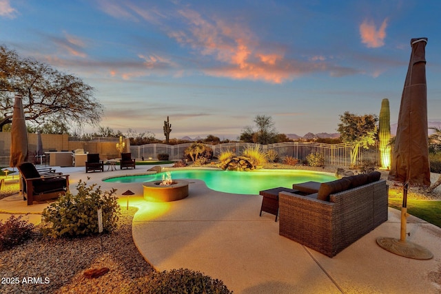 pool at dusk with a patio area and an outdoor living space with a fire pit