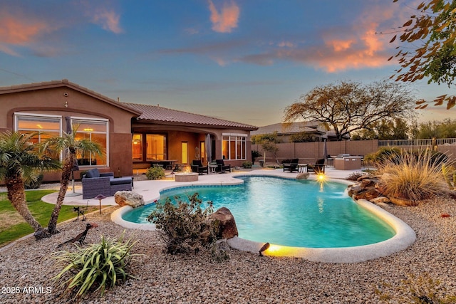 pool at dusk featuring a patio and outdoor lounge area