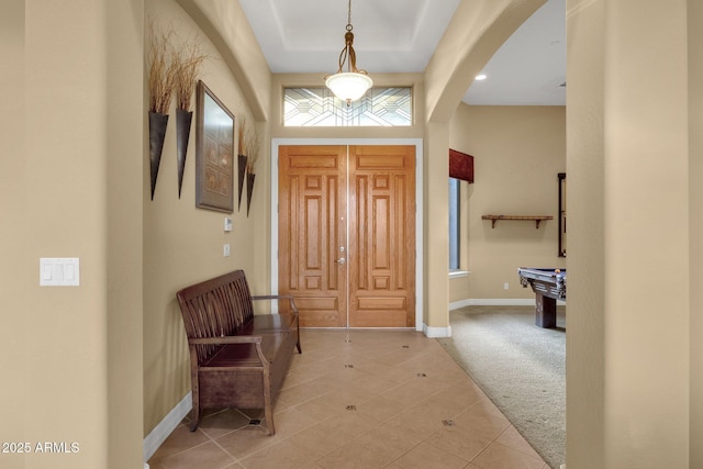 carpeted entryway with a tray ceiling