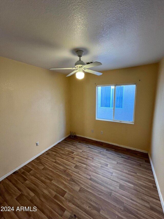 empty room with hardwood / wood-style flooring, ceiling fan, and a textured ceiling