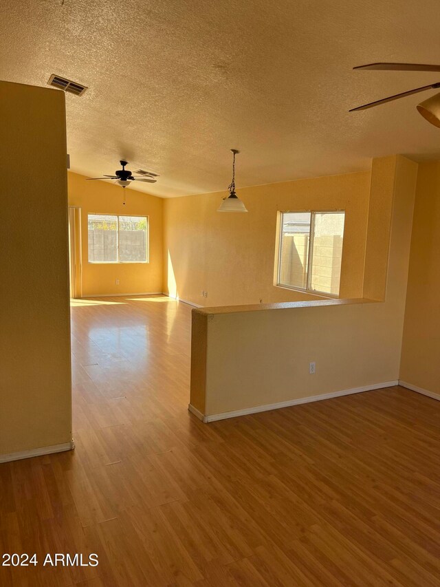 empty room featuring wood-type flooring, a textured ceiling, and ceiling fan