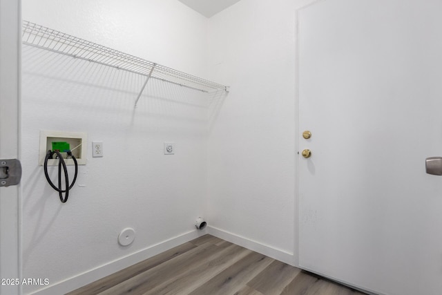 washroom with hardwood / wood-style flooring, hookup for a gas dryer, hookup for an electric dryer, and washer hookup