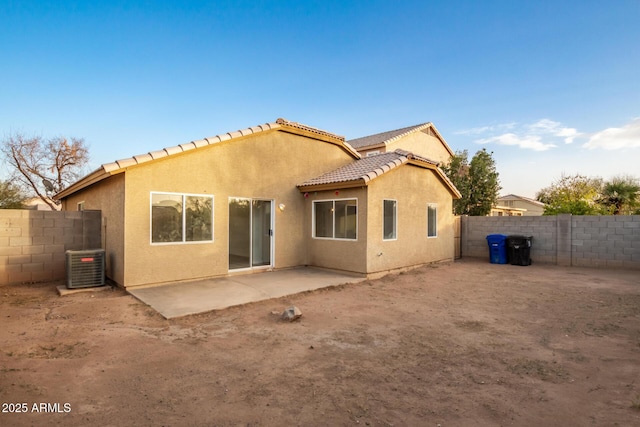 back of property with central AC and a patio