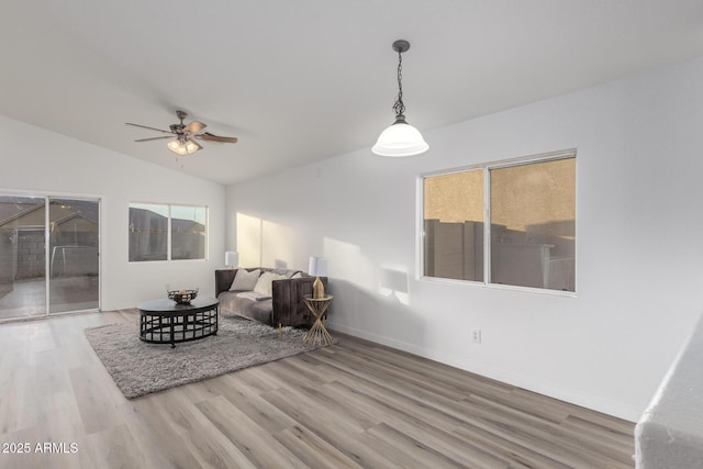 living room featuring hardwood / wood-style floors, ceiling fan, a wealth of natural light, and vaulted ceiling