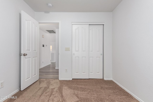 unfurnished bedroom with carpet flooring and a closet