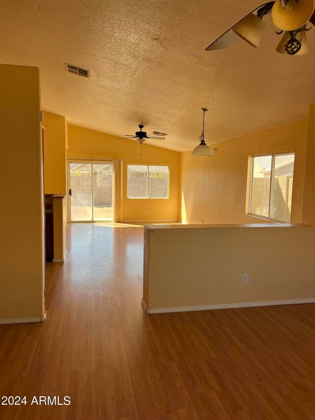 interior space featuring ceiling fan, a healthy amount of sunlight, wood-type flooring, and lofted ceiling