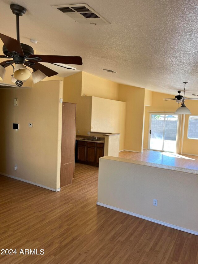 empty room featuring a textured ceiling, hardwood / wood-style flooring, and sink