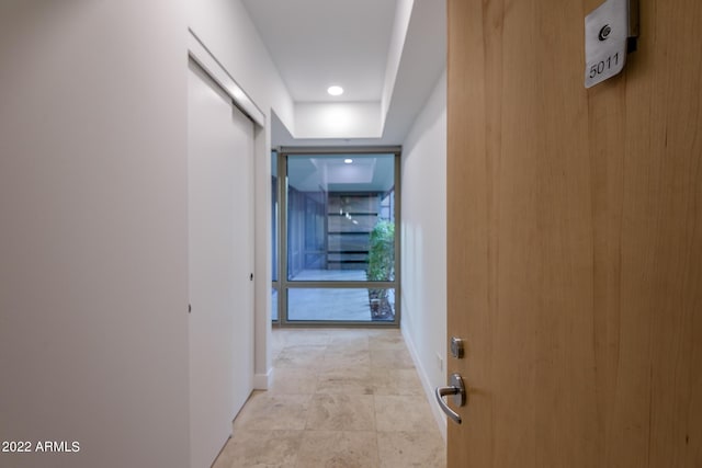 corridor with floor to ceiling windows and baseboards