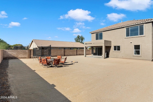 back of house with a trampoline and a patio