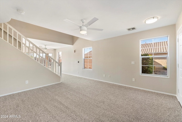 unfurnished living room featuring ceiling fan and carpet floors