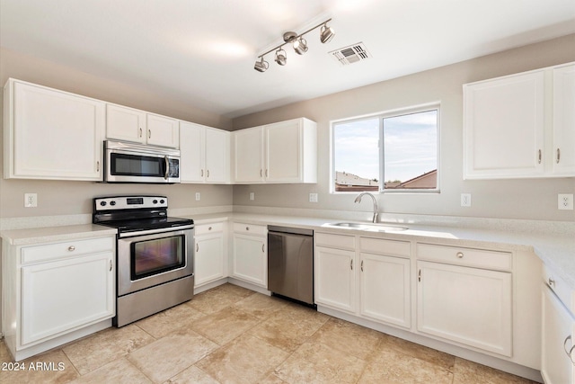 kitchen featuring white cabinetry, sink, appliances with stainless steel finishes, and track lighting