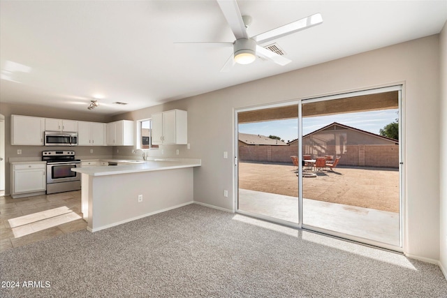 kitchen with white cabinets, appliances with stainless steel finishes, kitchen peninsula, and sink