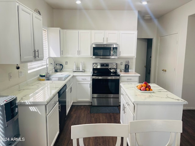 kitchen with white cabinetry, light stone countertops, stainless steel appliances, dark hardwood / wood-style floors, and sink