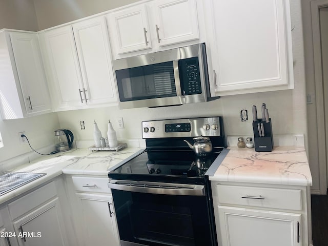 kitchen featuring light stone counters, white cabinets, and appliances with stainless steel finishes