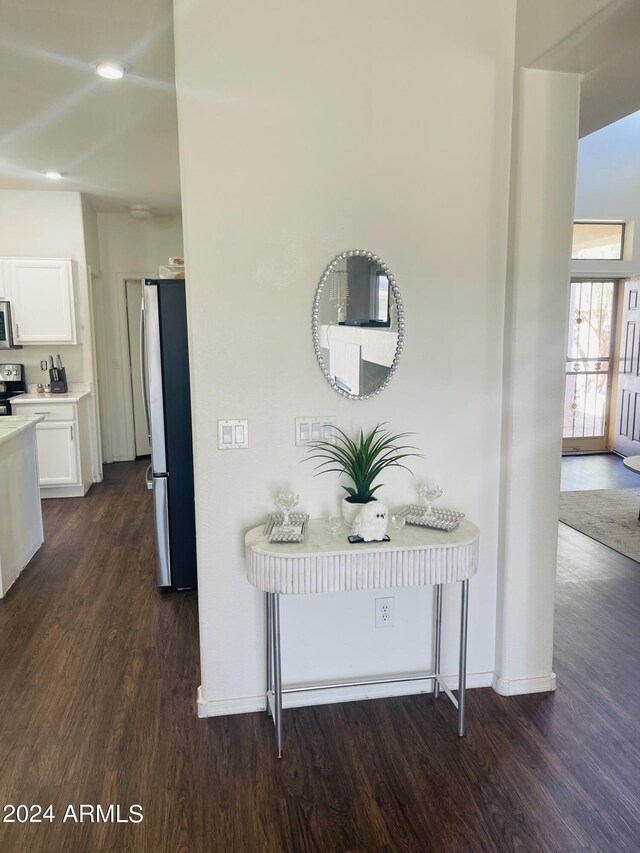 kitchen with white cabinets, dark hardwood / wood-style floors, and stainless steel fridge