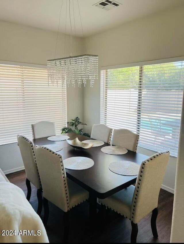 dining area featuring dark hardwood / wood-style flooring and a chandelier