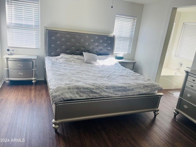 bedroom with connected bathroom and dark hardwood / wood-style flooring