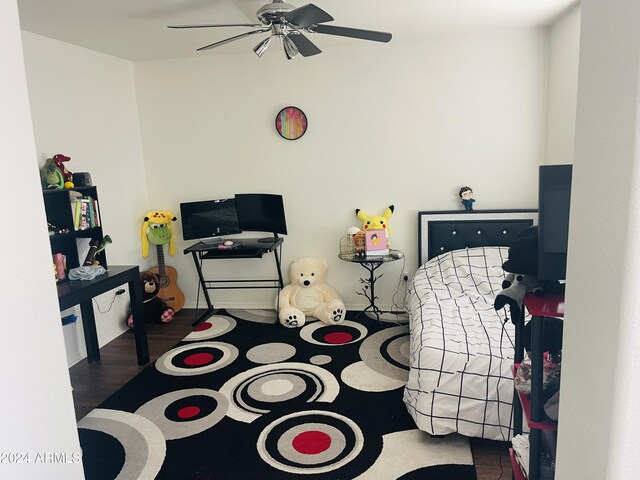 bedroom featuring dark hardwood / wood-style flooring, ceiling fan, and ensuite bath