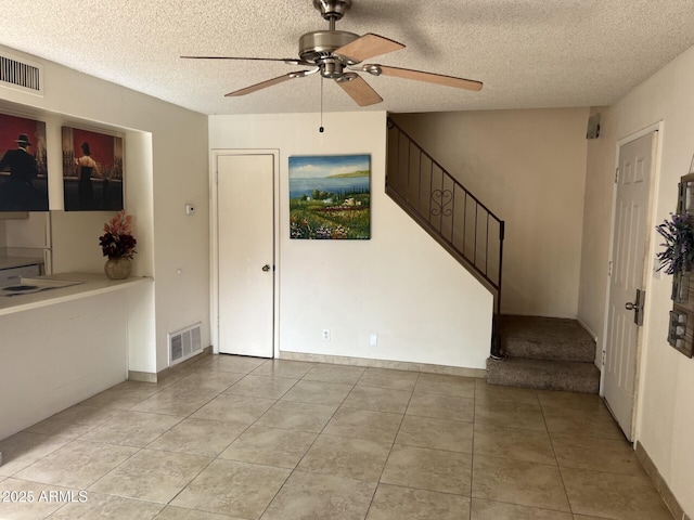 interior space featuring ceiling fan and a textured ceiling