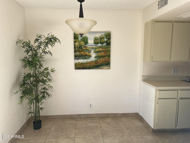 unfurnished dining area with light tile patterned floors and a textured ceiling