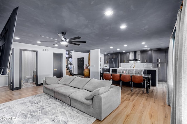 living room with ceiling fan and light hardwood / wood-style flooring