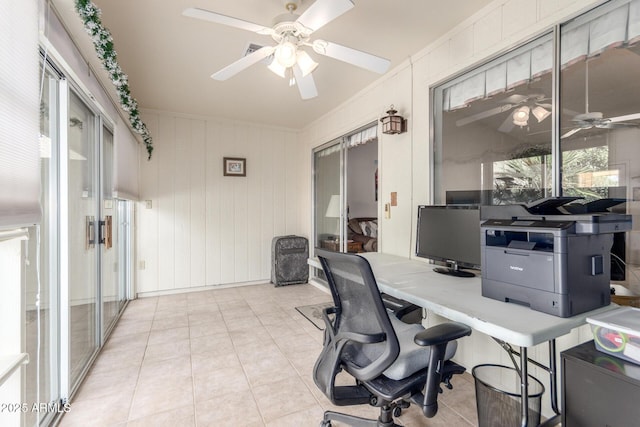 home office with light tile patterned floors and a ceiling fan