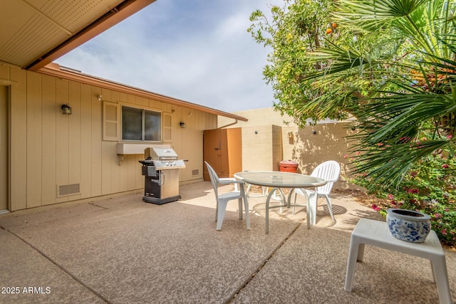 view of patio with grilling area, visible vents, and outdoor dining space