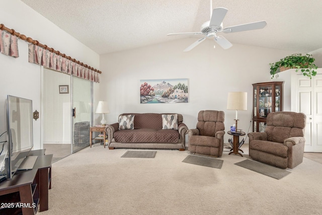 living room with carpet floors, a textured ceiling, lofted ceiling, and ceiling fan