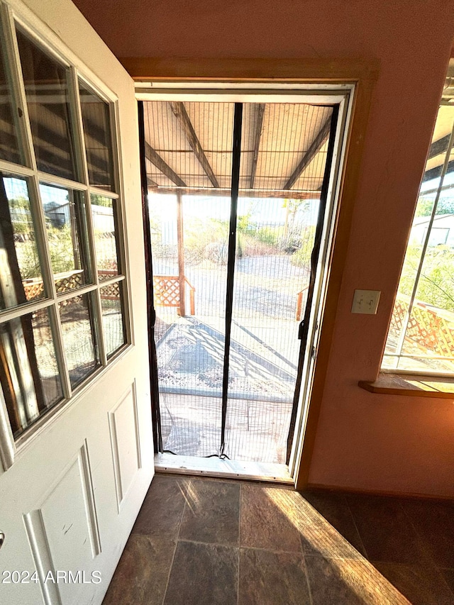 doorway to outside featuring dark tile floors