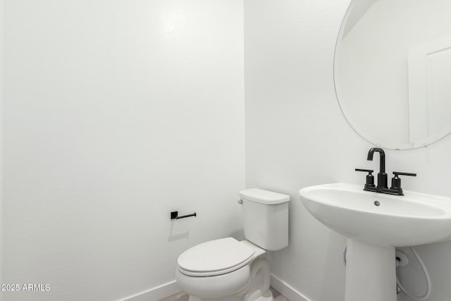 bathroom with toilet and baseboards