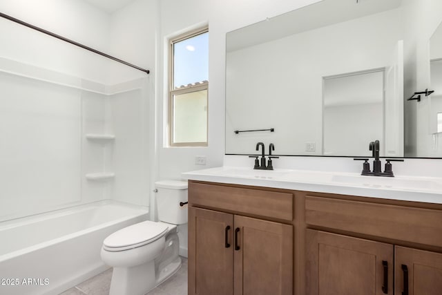 full bath featuring toilet, double vanity, a sink, and tile patterned floors