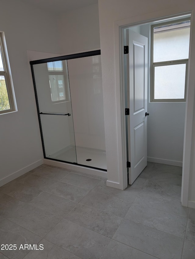 bathroom with a stall shower and baseboards