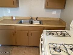 104 N Casa Grande Ave, Casa Grande, AZ 85122 - kitchen with white range with gas cooktop, light countertops, a sink, and light tile patterned floors
